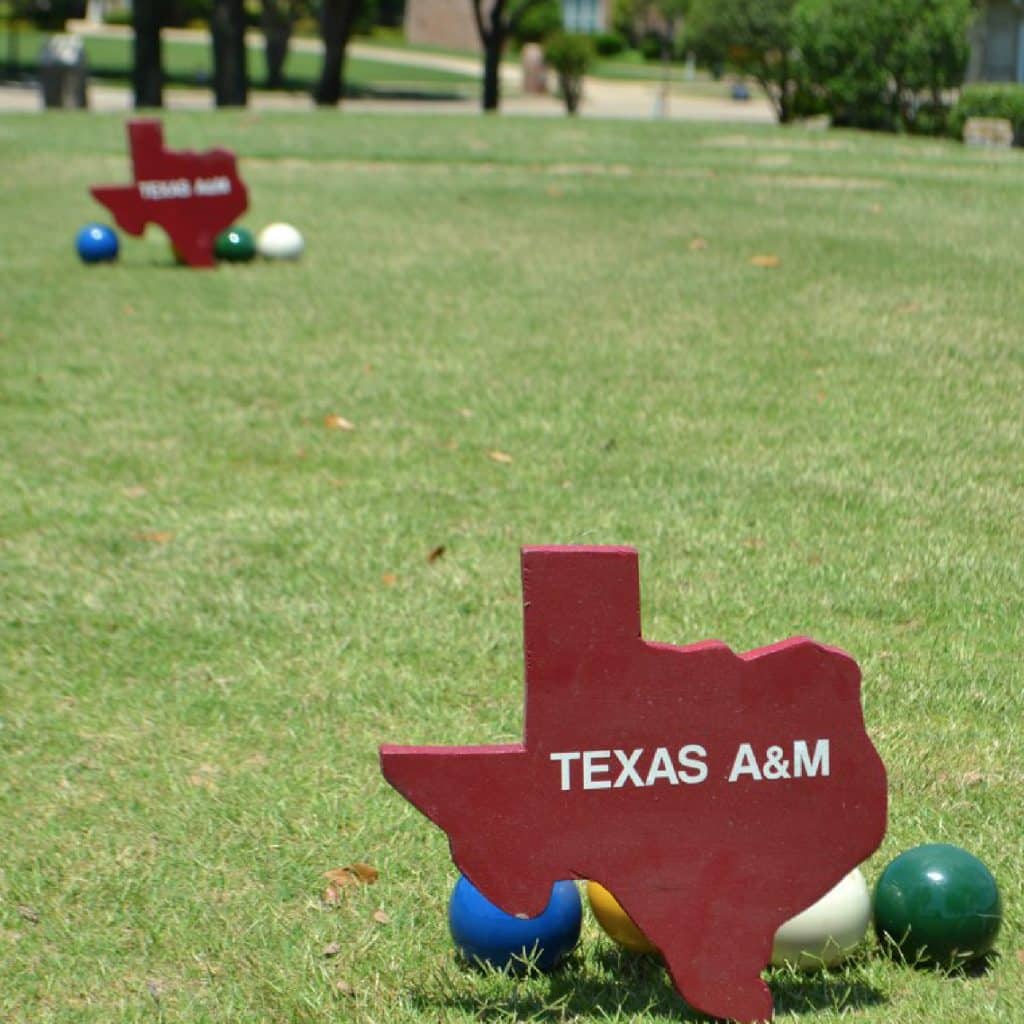 Grassy field with red Texas icon standee and with Texas A&M