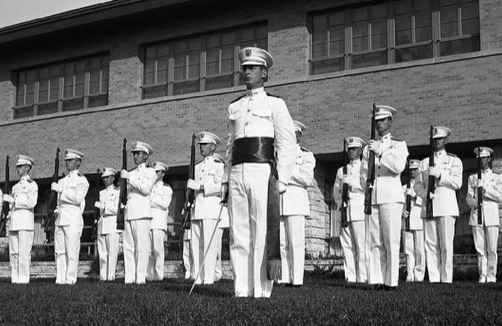Old photograph of Aggies wearing full, white uniform lining up